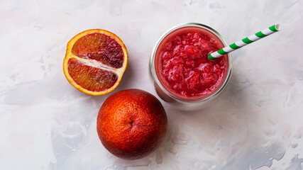 Red orange juice in a glass. Cocktail from Sicilian oranges. Creative minimal summer idea.