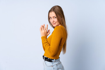 Teenager Ukrainian girl isolated on blue background scheming something