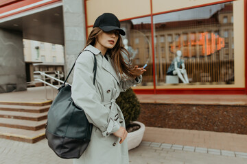 stylish girl in a trench walks around the city