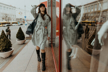 stylish girl in a trench walks around the city