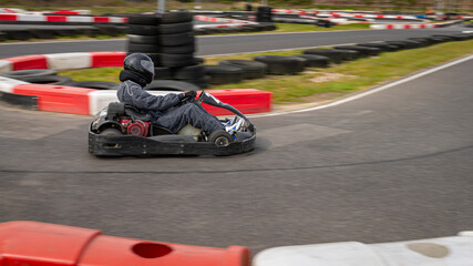 Fototapeta premium A panning shot of a racing kart as it circuits a track.
