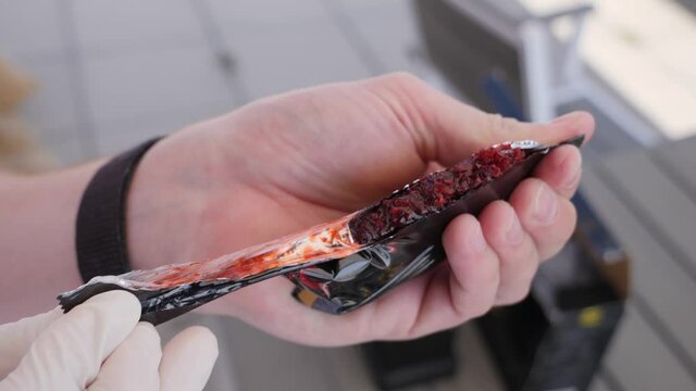 Close-up, caucasian man with white gloves opening a pack of shisha tobacco.