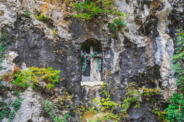 Wooden cross with a crucifix in the rock