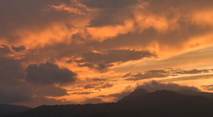 mountains with orange clouds in sunset golden hour