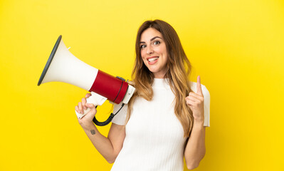 Caucasian woman isolated on yellow background holding a megaphone and pointing up a great idea