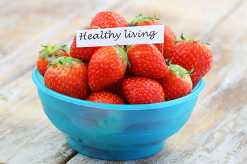 Healthy living note with sweet strawberries in blue bowl
