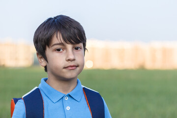 Returning to school concept, portrait of boy with backpack, school child waiting for school bus, primary school student, on the way to school © justoomm