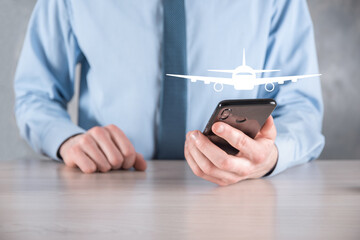 Businessman holding an airplane icon in his hands. Online ticket purchase.Travel