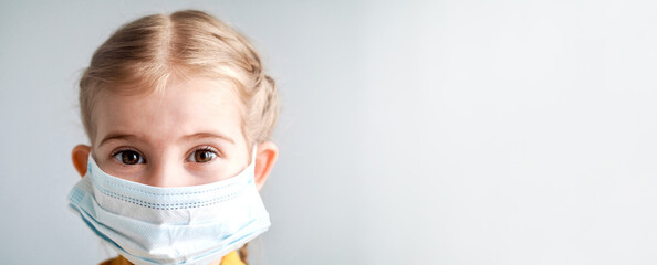 Coronavirus Covid-19. Little child girl wearing protection face medical mask on grey background. Stay home. Social distancing. School kid. Back to school. Banner with place for text