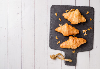 freshly baked croissants on white wooden table, top view