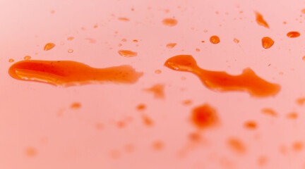Water drops on a pink texture background. Abstract liquid color background. Drop merge macro....