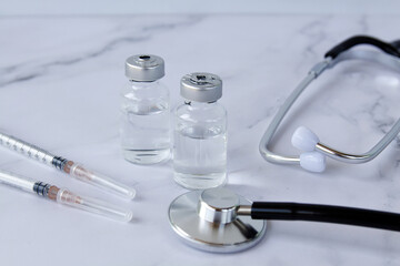 Vials and syringe on light background. Vaccination and immunization.