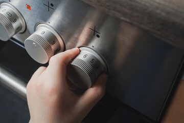 Hand Of A Child Switching On Stove Controls - Prevent Child Hazard Concept