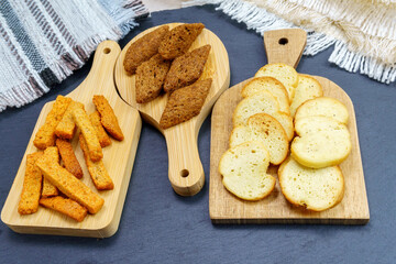different types croutons on wooden boards close-up, white, brown, dark