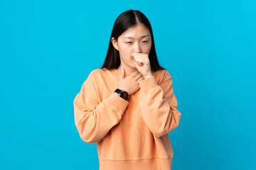 Young Chinese girl over isolated blue background coughing a lot
