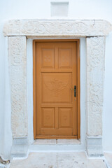 View of the white villa with brown door. Lefkes, Paros Island, Greece.