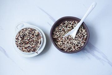 Tricolor quinoa scoop in white ceramic bowl