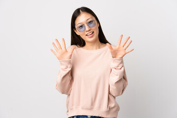 Young Chinese girl over isolated white background counting ten with fingers