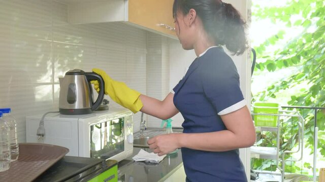 Housekeeper cleaning kitchen in the house.