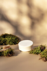 Healthcare concept with bath accessories on beige background with green moss