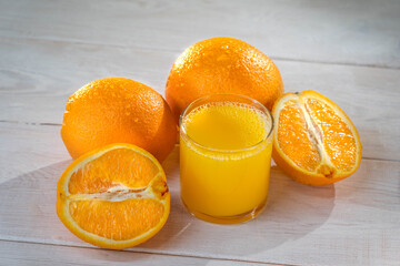 Orange juce, half of orange on the wooden white table. Summer mood. close up shot. raw footage