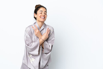 Woman wearing kimono over isolated background smiling and showing victory sign