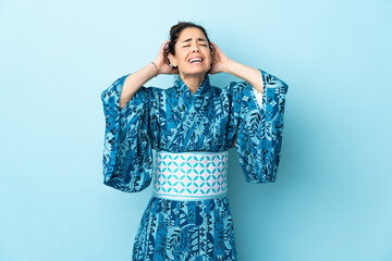 Woman wearing kimono over isolated background stressed overwhelmed