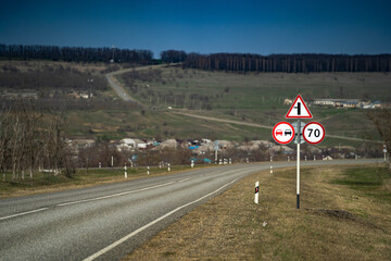 road sign overtaking is prohibited. road sign speed limit 70 km per hour. road sign turn right