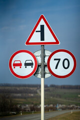 road sign overtaking is prohibited. road sign speed limit 70 km per hour. road sign turn right