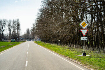 Road sign end of main road. road sign give way. 150 metres to crossroad