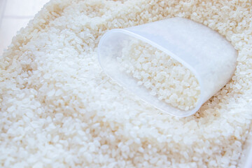 白いお米とプラスチックの計量カップ