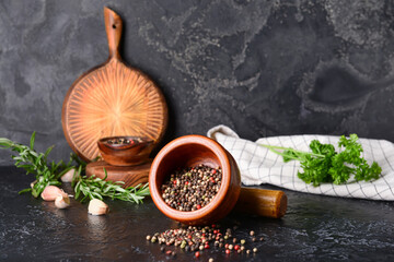 Mortar and pestle with peppercorns on dark background