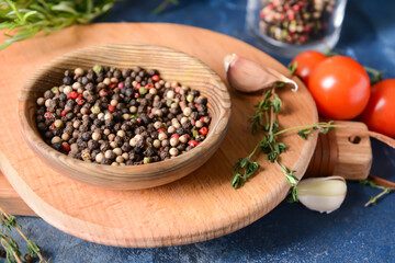 Plate with peppercorns on color background