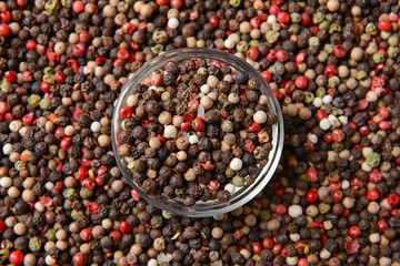 Bowl and peppercorns as background, closeup