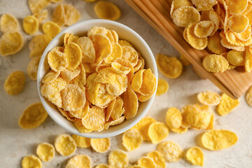 Bowl with tasty cornflakes on light background