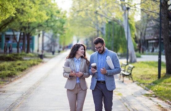 Two business people taking a walk in park