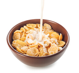 Pouring of milk into bowl with cornflakes on white background