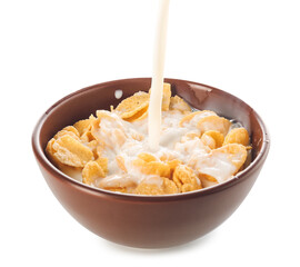 Pouring of milk into bowl with cornflakes on white background