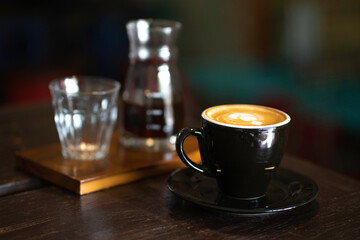 Black coffee and ice cubes served on a table in a coffee shop.