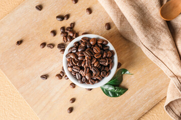 Bowl with coffee beans on wooden background