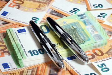 Euro close-up. Macro of money. Cash banknotes are stacked. Ballpoint pen. European currency                               