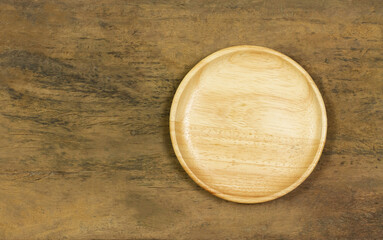 Empty wooden plate on wooden rustic table, top view.