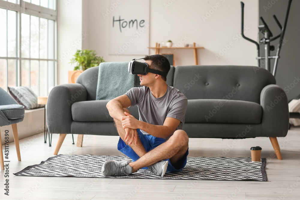 Wall mural young man with virtual reality glasses at home - Wall murals