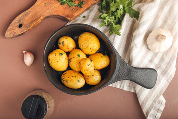 Frying pan of tasty potatoes with parsley on color background