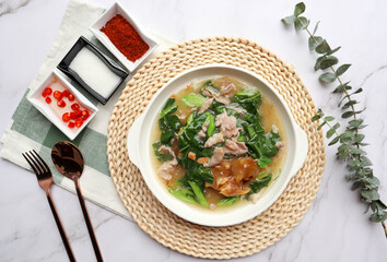 Stir Fried noodle with pork and kale in gravy sauce (Thai food called Rad Na Moo) - Top view with seasoning on marble background