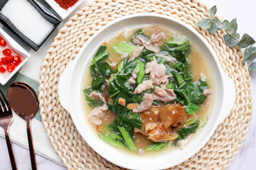 Stir Fried noodle with pork and kale in gravy sauce (Thai food called Rad Na Moo) - Top view with seasoning on marble background