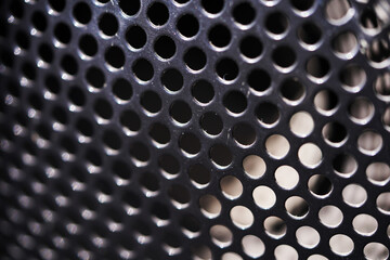 Metal texture with holes. Iron gray perforated background. Steel durable material. Circles in the...