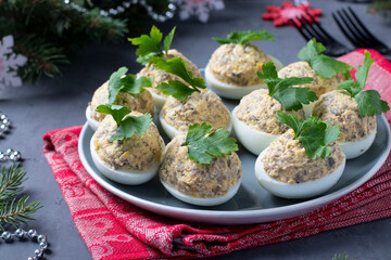 Stuffed eggs with cheese and champignons on dark gray background. Festive snack. Close-up