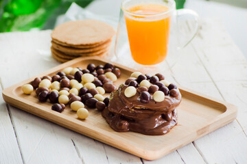 Obleas recubiertas de crema de avellanas y bolitas de chocolate con zumo de naranja