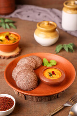 South Indian breakfast Ragi Idly, nachni idly, finger millet Idli in clay plate Sambar, coconut chutney healthy homemade dish Kerala, Karnataka, Tamil Nadu, India, Sri Lanka. steam cooked food. 